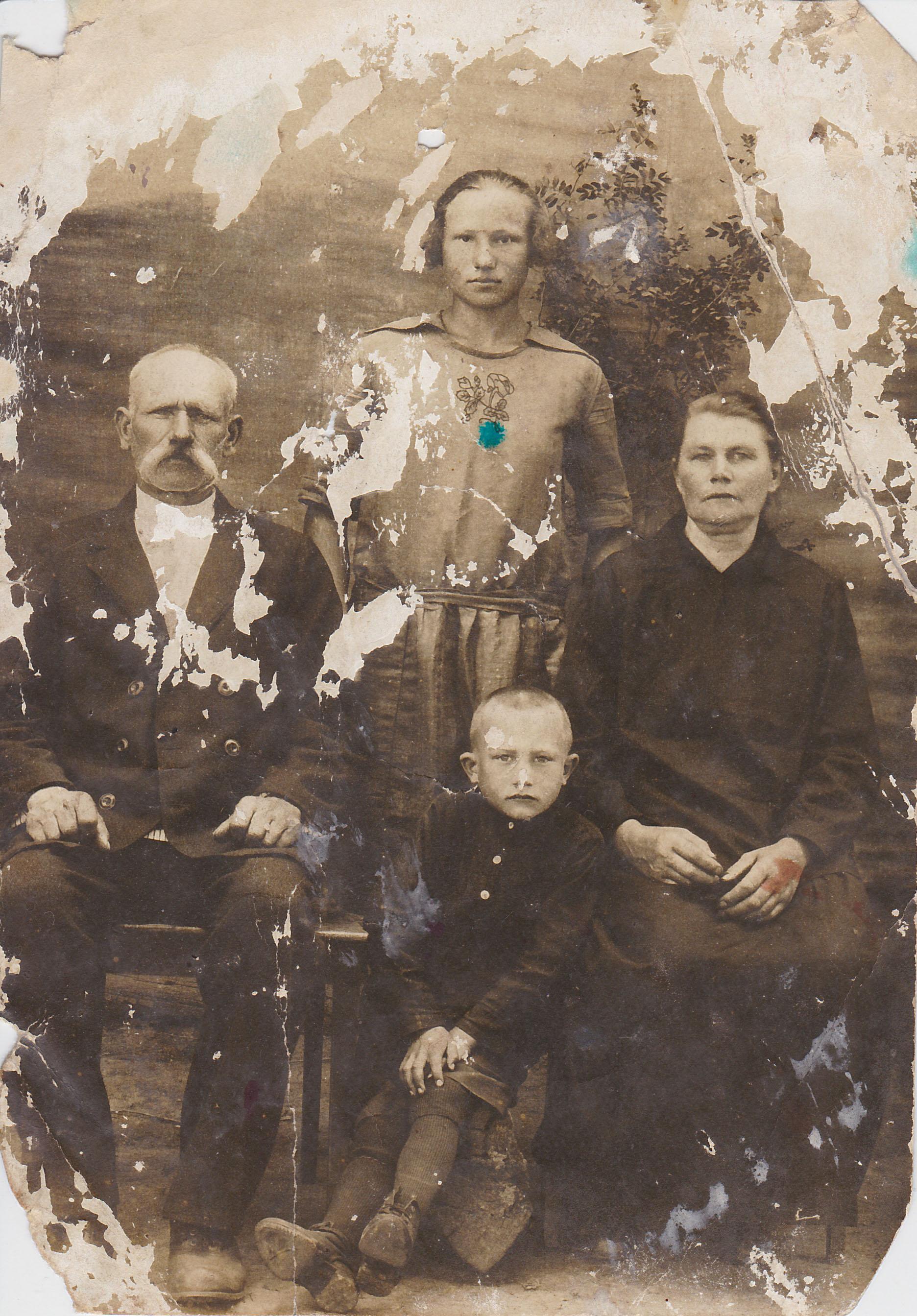 Original MH-E2 damaged four-person family portrait with severe peeling, surface loss and large missing regions.